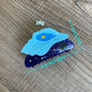Vue détaillée de la pince à cheveux coquillage bleu avec dimensions sur bois
