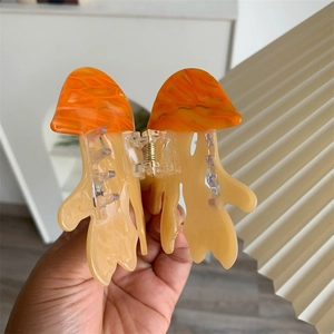 Detail of creative jellyfish hair claw clip with orange marbling and strong spring