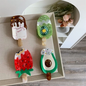 Detailed view of creative fruit popsicle acetate hair claws in strawberry and kiwi shapes