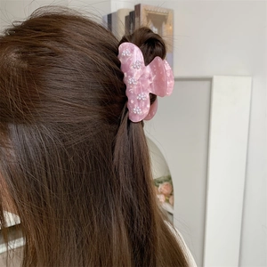 Detailansicht der Haarspange aus rosa Marmor-Acetat mit feinen Perlenblumen-Akzenten