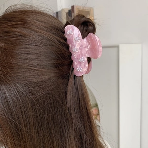 Detailansicht der rosa Schmetterlings-Haarklammer mit Perlenblume und Marmor-Textur