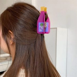 Detailed view of a purple juice bottle hair claw clip holding long brown hair securely
