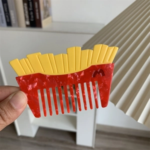 Dettaglio di un pettine creativo a forma di patatine con trama in marmo rosso e giallo
