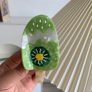 Detail shot of a kiwi popsicle hair claw made of premium acetate with marble texture