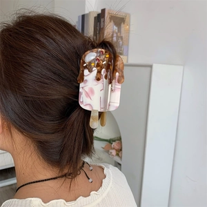 Detail of ice cream shaped hair claw clip in chocolate and pink worn on hair