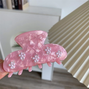 Nahaufnahme der Haarspange aus rosa Acetat mit Marmormuster und Perlenblumen-Dekor