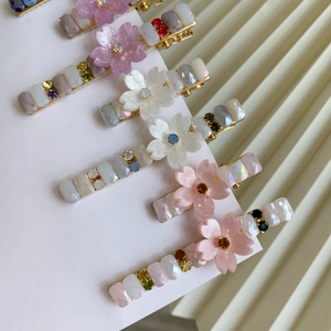 Vue détaillée de pinces à cheveux fleuries de style pastoral avec strass colorés sur support