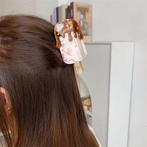 Detail view of acetate ice cream hair claw clip with chocolate and pink marble design