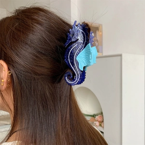 Détail d'une pince à cheveux hippocampe bleue scintillante sur cheveux longs