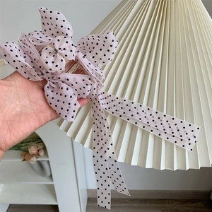 Detail of pink polka dot chiffon bow hair claw clip with long tassels and rhinestone
