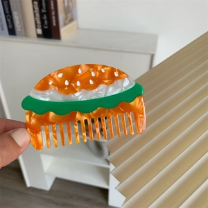Dettaglio del pettine in acetato a forma di hamburger con strati colorati vivaci