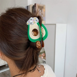 Detailed view of avocado ice cream hair claw clip styled on long brown wavy hair