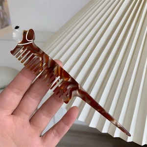 Dettaglio ravvicinato di un pettine in acetato tartarugato con design a bassotto