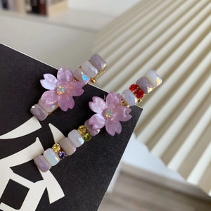 Gros plan de barrettes à fleurs avec fleurs de cerisier en résine et perles de cristal