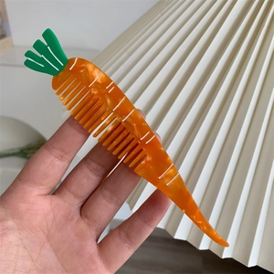 Dettaglio di un pettine creativo in acetato a forma di carota con finitura marmorizzata