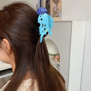 Détail de la pince à cheveux méduse bleu clair avec paillettes et étoile jaune sur cheveux