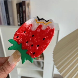 Detail shot of a strawberry ice cream shaped acetate hair claw clip with melting cream effect