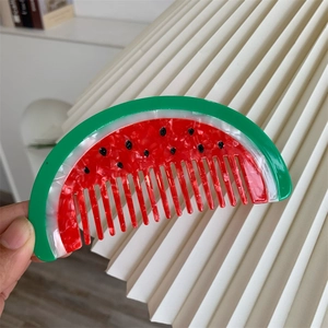 Dettaglio ravvicinato di un piccolo pettine per capelli in acetato a forma di anguria
