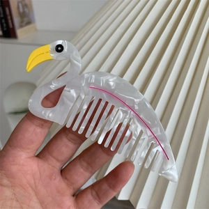 Dettaglio di un pettine per capelli a forma di fenicottero con trama in acetato marmoreo