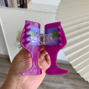 Detailed view of two purple acetate wine glass hair claws with grape patterns