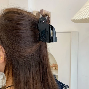 Close-up of a cute black cat cellulose acetate hair claw clip styled on dark brown hair