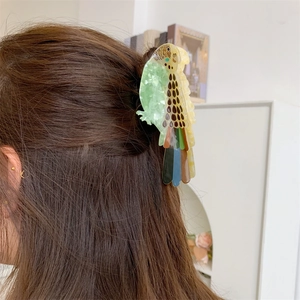 Detail view of a colorful parrot acetate hair claw clip styled on a woman hair