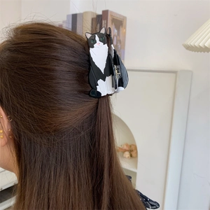 Detail of creative black and white tuxedo cat acetate hair claw clip on long hair