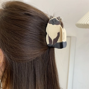 Detail of Siamese cat hair claw clip made of cream and brown acetate on a model's hair