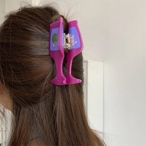 Detail view of a purple acetate hair claw clip shaped like a wine glass with grape patterns