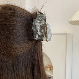 Detail view of a creative cat-shaped acetate hair claw clip with grey tabby textures