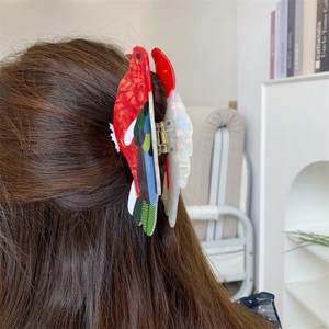 Parrot shaped acetate hair claw clip showing side view on brunette hair for hair styling
