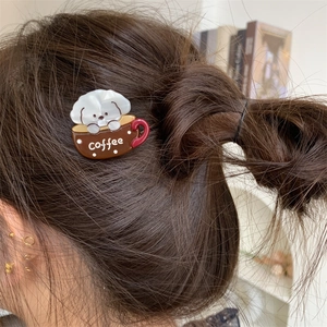 Close-up of a cute dog and coffee cup acetate hair clip worn on brown hair