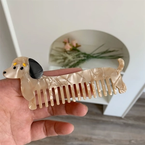 Dettaglio di un pettine a forma di bassotto in acetato di alta qualità effetto marmo