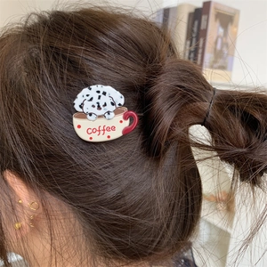 Close-up of a cute dalmatian dog in a coffee cup hair clip worn on a brown hair bun