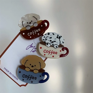 Detailed macro view showing three cute puppy and coffee cup acetate hair clips on display card