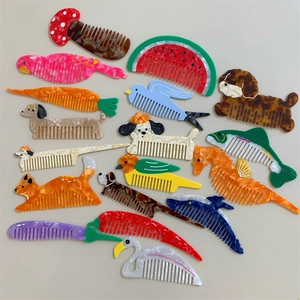 Vari pettini in acetato con design creativi di animali e frutta da portare sempre