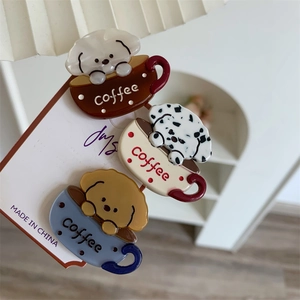 Detailed view of three cartoon puppy coffee hair clips in brown, beige, and blue acetate