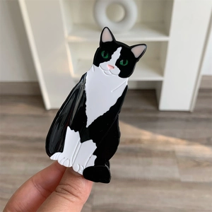 Detail view of tuxedo cat hair claw made of polished black and white acetate material