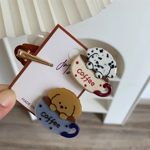 Detailed close-up of cute coffee cup hair clips with puppy patterns and acetate finish