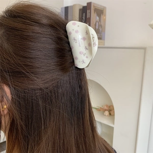 Détail de la pince à cheveux florale crème avec fleurs roses et strass dans les cheveux