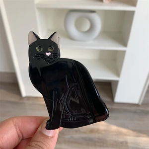 Detail view of the black acetate cat hair claw clip showing glossy finish and cat features