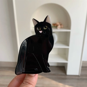 Close-up of a glossy black acetate cat hair claw clip with pink heart-shaped nose detail