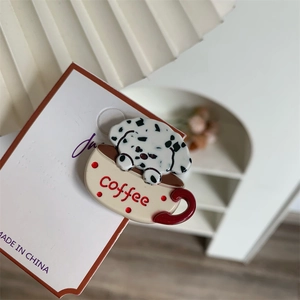 Close-up of cute Dalmatian puppy in coffee cup enamel brooch on white card