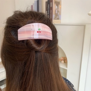 Pink acetate hair claw clip with crystal cherry patterns on long brown hair