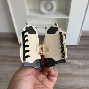 Detailed macro view of black and white cartoon cat hair claw clip with metal spring