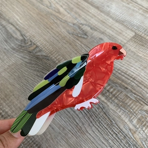 Detailed close-up of a colorful parrot-shaped acetate hair claw clip with vibrant patterns