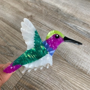 Detailed macro view of colorful hummingbird acetate hair claw with iridescent texture