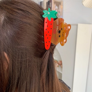 Vue détaillée d'une pince à cheveux créative en acétate avec ours et carotte sur cheveux