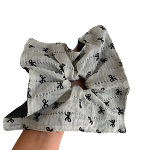 Vintage white oversized scrunchie with black embroidered bow patterns and ruffle details