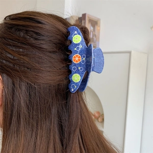 Dettaglio molletta per capelli blu denim con decorazioni di fette di limone e arancia